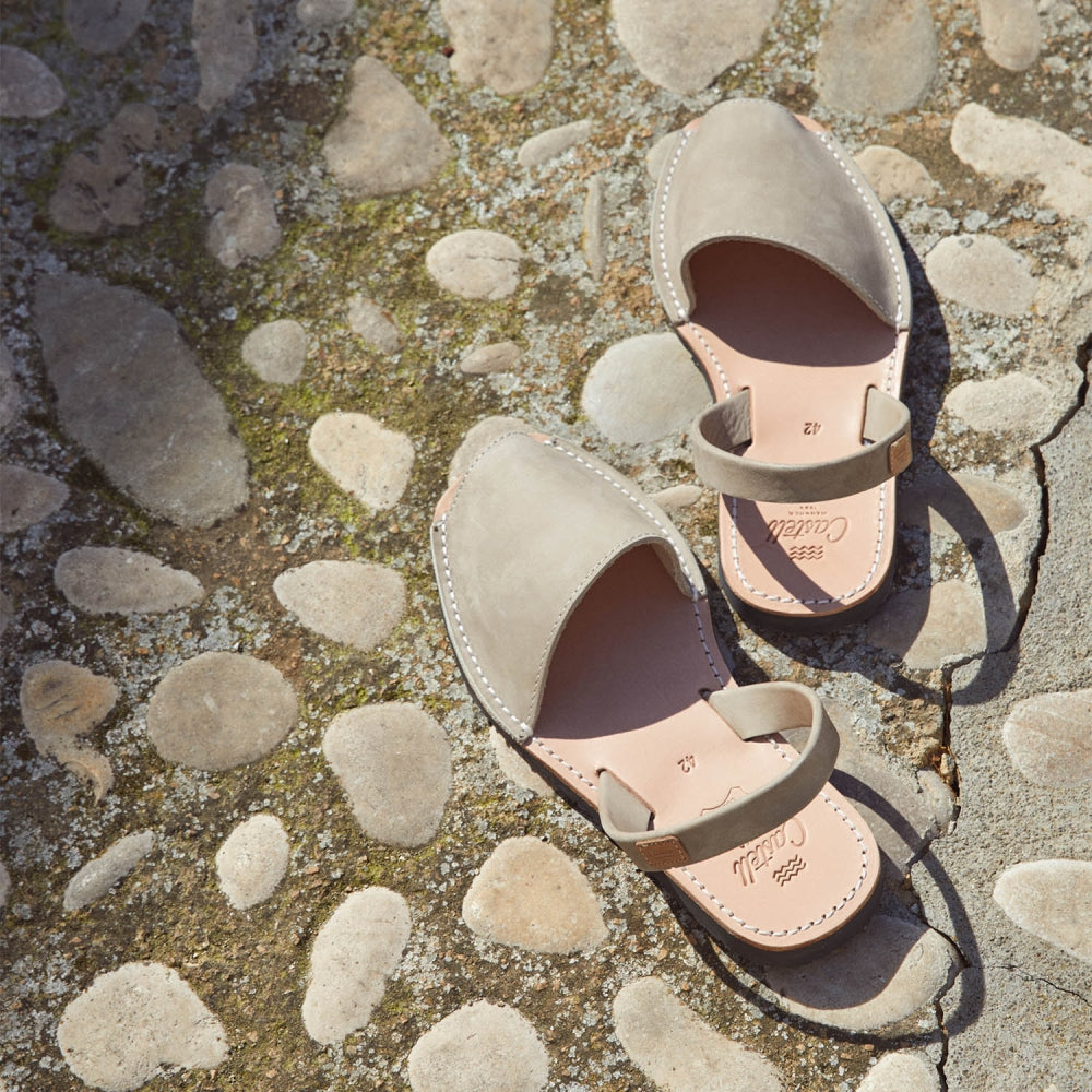 A pair of authentic Menorcan sandals, avarcas, on a cobblestone road in Menorca.