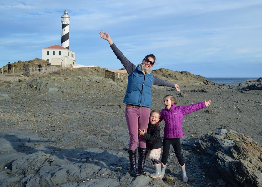A happy family visiting one of Menorca's most famous and picturesque lighthouses on the north coast of the island, near the capital city of Mahón